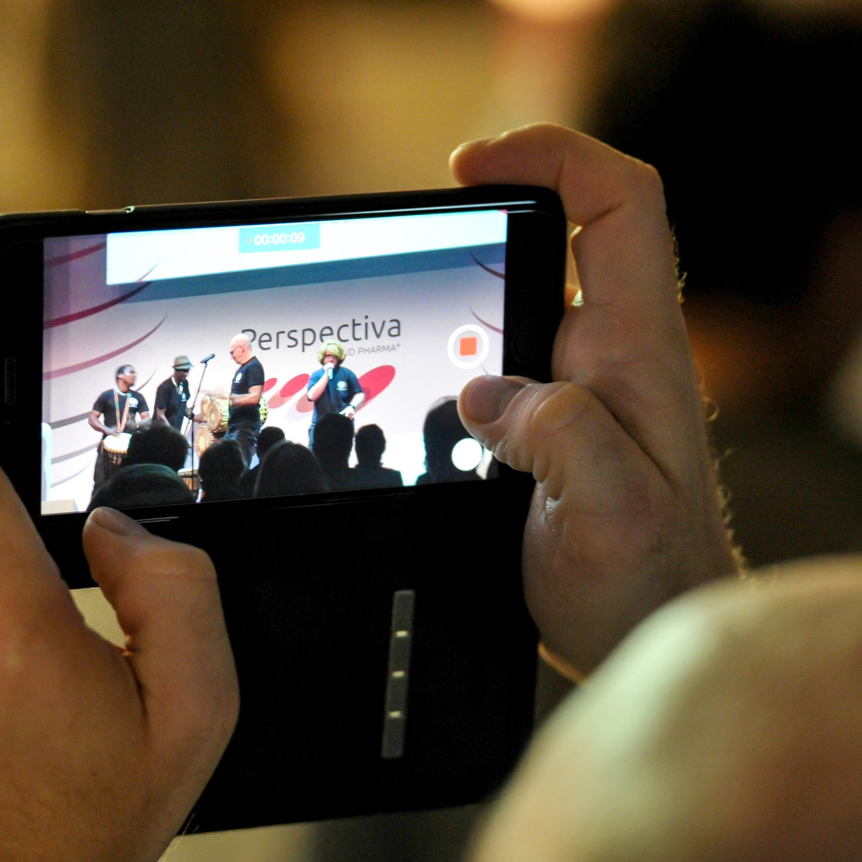 Aliud Pharma: Blick auf das Handy eines Gastes der die Bühne fotografiert.