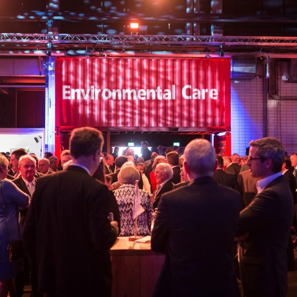 BLG Logistics Jubiläum: Blick in den Saal mit Gästen. Im Hintergrund stehen Container