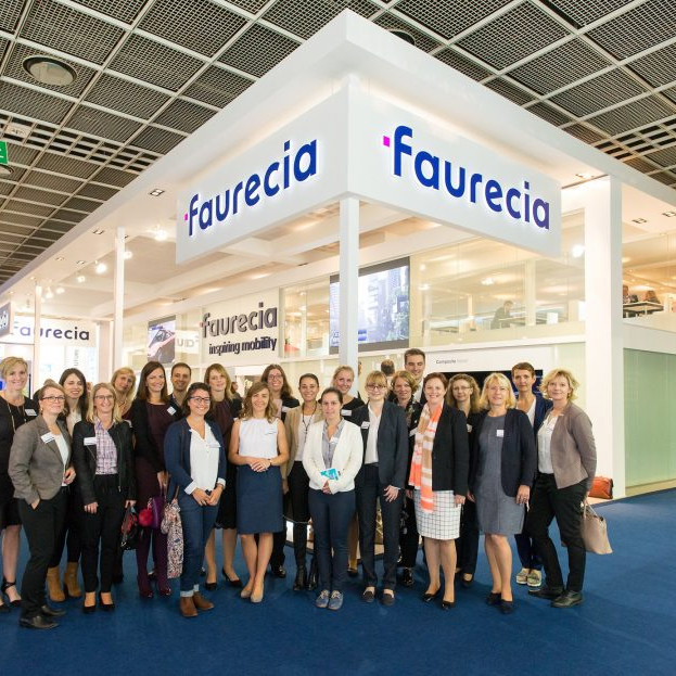 Faurecia Messe: Gruppenbild in der Messehalle mit allen Mitarbeitern vor dem Messestand.