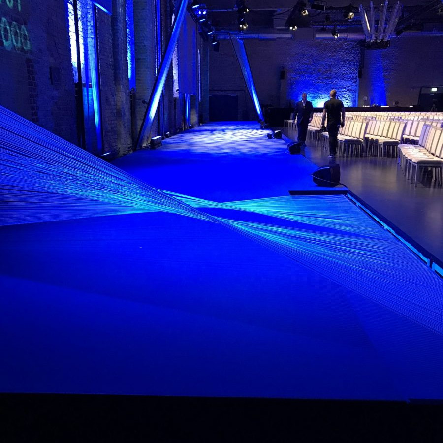 Fraunhofer Jahrestagung: Blich von der Seite auf die Bühne, die komplett blau ausgeleuchtet ist.