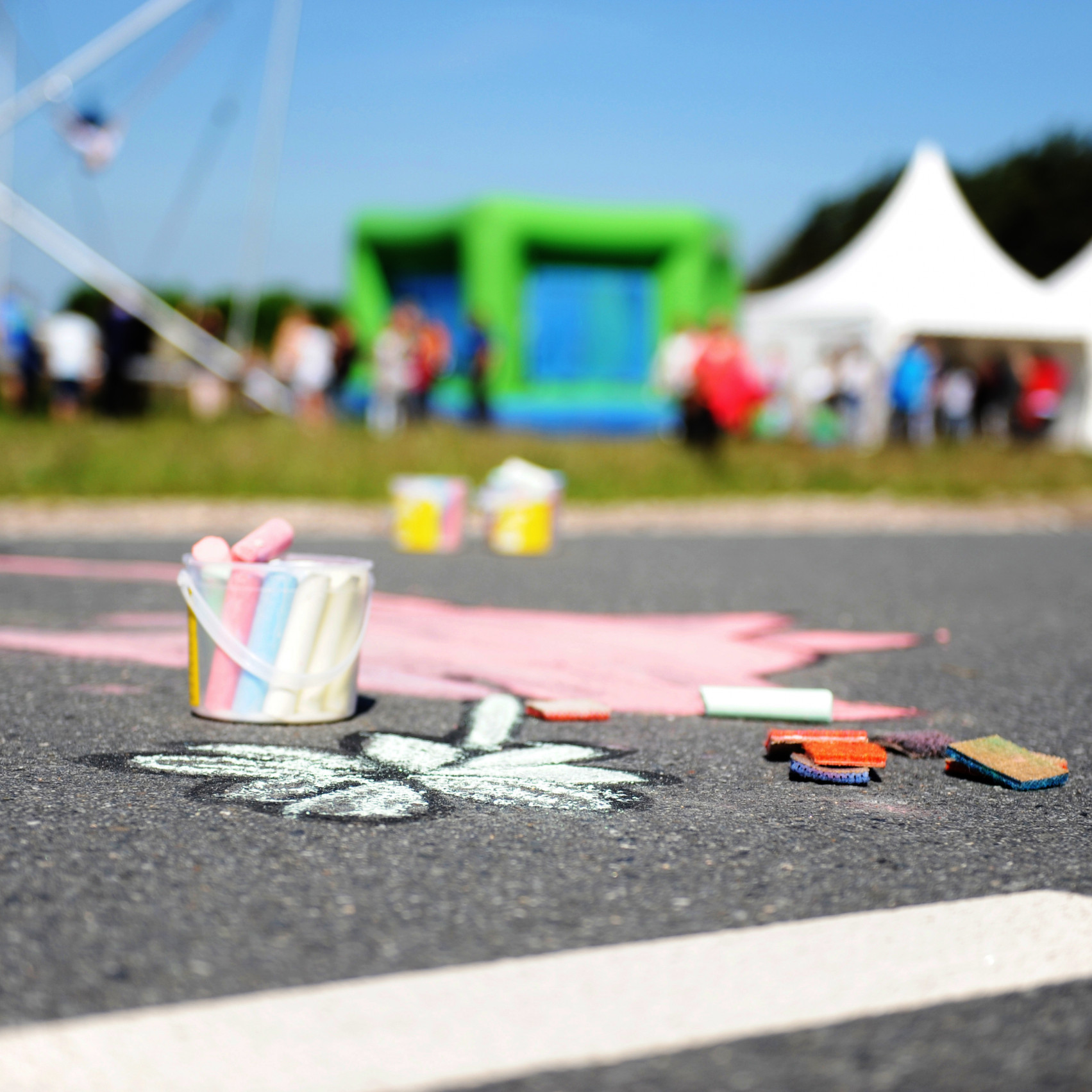 Göbber Mitarbeiterfrühstück: Auf der Strasse ist ein kleines Schmetterling mit Kreide gemalt. Daneben steht ein kleiner Eimer mit Kreide.