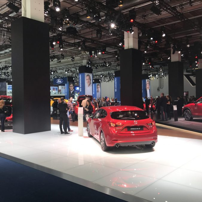 Mazda Messeaktivierung IAA: Heckansicht eines roten Mazda auf dem Messestand.